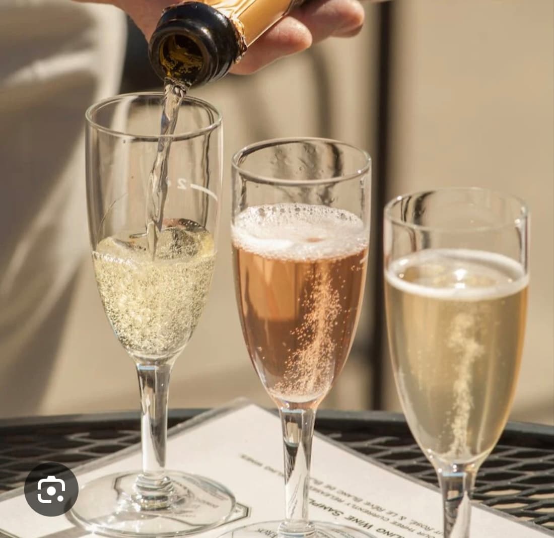 Sparkling wine being poured into three flutes at a Netwrk Hub gathering